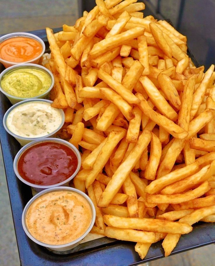 Porção de batatas fritas crocantes com molhos variados